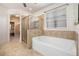 Soaking tub and separate shower in the bright and neutral main bathroom at 233 Millstone Pkwy, Woodstock, GA 30188