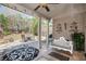 Covered patio area with white bench swing and outdoor seating area at 233 Millstone Pkwy, Woodstock, GA 30188