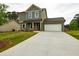 Two-story home with green siding, a two-car garage and green lawn at 358 Forkview Dr, Lawrenceville, GA 30044