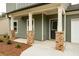 Charming front porch with brick-based pillars and green siding at 358 Forkview Dr, Lawrenceville, GA 30044