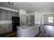 Bright kitchen with gray cabinets, stainless steel appliances, island with granite countertops, and vinyl floors at 358 Forkview Dr, Lawrenceville, GA 30044