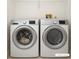 Modern laundry room featuring front loading washer and dryer set, with added storage shelf at 485 Sherman Way, Decatur, GA 30033