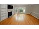 Bright living room with hardwood floors, built-in shelving, fireplace, and access to the patio at 485 Sherman Way, Decatur, GA 30033