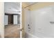 Bathroom with white tile, shower and view into a bedroom with gray walls and carpet at 5826 Sarazen Trl, Douglasville, GA 30135