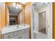 Bright bathroom with a single sink vanity, a large mirror, and an adjacent toilet room at 5826 Sarazen Trl, Douglasville, GA 30135