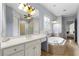 Bathroom showcasing jacuzzi tub, vanity, and walk-in shower with glass block accent at 5826 Sarazen Trl, Douglasville, GA 30135