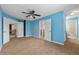 Blue bedroom with adjoining bath and hallway, ceiling fan, and carpeted floor at 5826 Sarazen Trl, Douglasville, GA 30135
