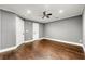 A gray bedroom featuring hardwood floors, a ceiling fan, and white doors at 5826 Sarazen Trl, Douglasville, GA 30135