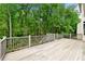 A large outdoor deck with railings surrounded by lush trees at 5826 Sarazen Trl, Douglasville, GA 30135