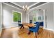 Open dining room with hardwood floors, chandelier, and views of the outdoor greenery and fireplace at 5826 Sarazen Trl, Douglasville, GA 30135
