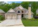 Charming brick home with three-car garage, manicured lawn, and stately stone chimney at 5826 Sarazen Trl, Douglasville, GA 30135