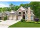 Beautiful brick home features a three-car garage, manicured lawn, and stone chimney at 5826 Sarazen Trl, Douglasville, GA 30135