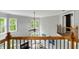Upstairs foyer with a view of the vaulted living room, tall windows, and decorative railing at 5826 Sarazen Trl, Douglasville, GA 30135