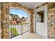 Charming front porch with stone archway, black railing, and a view of the front yard and neighborhood at 5826 Sarazen Trl, Douglasville, GA 30135