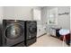 Well-lit laundry room featuring a modern washer and dryer, white cabinets, and a utility sink at 5826 Sarazen Trl, Douglasville, GA 30135