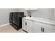 Laundry room featuring black washer and dryer, white cabinets, and counterspace at 5826 Sarazen Trl, Douglasville, GA 30135