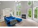 Spacious living room with soaring windows, fireplace, and comfortable blue seating, adjacent to dining area at 5826 Sarazen Trl, Douglasville, GA 30135
