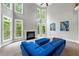 Modern living room features a fireplace, large windows with backyard views, and stylish blue sofa at 5826 Sarazen Trl, Douglasville, GA 30135