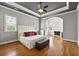 Main bedroom with hardwood floors, fireplace, with a tray ceiling and modern ceiling fan at 5826 Sarazen Trl, Douglasville, GA 30135