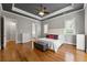 Main bedroom with hardwood floors, fireplace, and tray ceiling with ceiling fan at 5826 Sarazen Trl, Douglasville, GA 30135