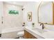 Bright bathroom features a tub-shower with white tile and a wood vanity with marble countertop at 1042 Oakdale Se Dr, Smyrna, GA 30080