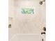 Bright bathroom featuring a white tiled shower with a small window and plant at 1042 Oakdale Se Dr, Smyrna, GA 30080