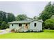Charming single-story home featuring a well-manicured lawn and welcoming front porch with wood stairs at 1042 Oakdale Se Dr, Smyrna, GA 30080