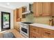 Modern kitchen features wooden cabinets, stainless steel appliances, and a stylish tile backsplash at 1042 Oakdale Se Dr, Smyrna, GA 30080