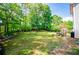Picturesque backyard with mature trees and level lawn, patio dining set, and providing a private outdoor oasis at 210 Creekside Overlook, Hiram, GA 30141