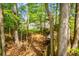 Wooded area with home in background and featuring well-maintained lawn, patio, and level, private location at 210 Creekside Overlook, Hiram, GA 30141