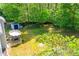 Aerial view of backyard with storage shed, patio dining set, and surrounded by mature trees for privacy and tranquility at 210 Creekside Overlook, Hiram, GA 30141