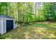 Backyard showing storage shed, level lawn, and backdrop of mature trees at 210 Creekside Overlook, Hiram, GA 30141