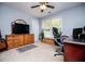 Bright bedroom with a large window, wooden dresser, and comfortable office chair at 210 Creekside Overlook, Hiram, GA 30141