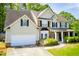 Charming two-story home with a well-manicured lawn, mature trees, and a two-car garage at 210 Creekside Overlook, Hiram, GA 30141
