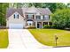 Beautiful two-story home with lush green lawn, traditional design, and inviting curb appeal at 210 Creekside Overlook, Hiram, GA 30141