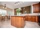 Open kitchen with wooden island, countertops, wooden cabinets, tile floor, and open to dining room at 210 Creekside Overlook, Hiram, GA 30141