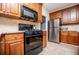 Traditional kitchen with stainless steel fridge, black oven, stone countertops and wooden cabinets at 210 Creekside Overlook, Hiram, GA 30141
