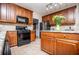 Kitchen with cabinets, countertops, black oven, stainless steel fridge, and tile floor at 210 Creekside Overlook, Hiram, GA 30141