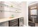 Wet bar has wine fridge and floating shelves, and a full bathroom with mosaic tiles at 3167 Bay View Dr, Jonesboro, GA 30236