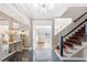 Elegant foyer with a mirrored wall, chandelier, tile flooring, and staircase with metal railing at 3167 Bay View Dr, Jonesboro, GA 30236