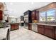 A chef's kitchen with stainless steel appliances, granite counters, and ample cherry wood cabinetry at 3167 Bay View Dr, Jonesboro, GA 30236