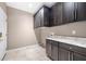 Well-lit laundry room with stone countertops, ample cabinets and a door to the exterior at 3167 Bay View Dr, Jonesboro, GA 30236
