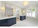 This spacious bathroom offers double vanities, marble countertops, blue cabinets, tiled floors and chandelier at 4005 N Stratford Ne Rd, Atlanta, GA 30342