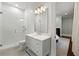 Modern bathroom featuring tiled shower, grey vanity, and views through doorway to adjacent bedroom with fireplace at 4005 N Stratford Ne Rd, Atlanta, GA 30342