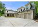 Rear exterior showcasing the spacious three-car garage, white brick, and nice backyard at 4005 N Stratford Ne Rd, Atlanta, GA 30342
