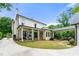 Rear exterior featuring a covered patio, connected three car garage, and circular driveway at 4005 N Stratford Ne Rd, Atlanta, GA 30342