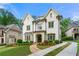 Elegant two-story white brick home featuring a well-manicured lawn, stone walkway, and a concrete driveway at 4005 N Stratford Ne Rd, Atlanta, GA 30342