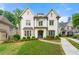 Elegant two-story white brick home featuring a well-manicured lawn, stone walkway, and a concrete driveway at 4005 N Stratford Ne Rd, Atlanta, GA 30342