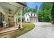 Backyard view showcasing a three car garage, green lawn, and a covered patio at 4005 N Stratford Ne Rd, Atlanta, GA 30342