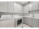 Well-equipped laundry room with modern washer, dryer, sink, and white cabinets for storage at 4005 N Stratford Ne Rd, Atlanta, GA 30342